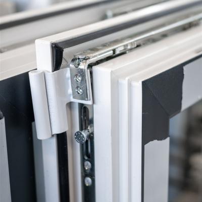 Das Bild zeigt eine detailreiche Nahaufnahme eines Fensterbeschlags mit Scharnier, Dichtung und Verriegelungstechnik.